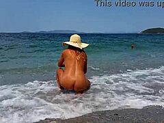 해변에서 늘어진 젖꼭지 피어싱과 여러 개의 피어싱을 가진 성숙한 여성