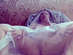 Aroused mature woman reaches climax while pleasuring herself under sheer fabric