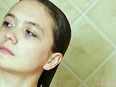 매력적인 갈색 머리 모델이 뜨거운 샤워에서 목욕을 합니다