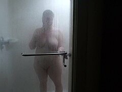 En vit flicka tar en snabb dusch på hotellet