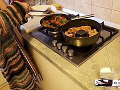 Samenvatting van een huisvrouw met grote borsten die een snel diner bereidt naakt in de keuken